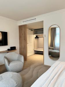 a bedroom with a bed and a chair and a mirror at ADELANTE Boutique Hotel in Berlin