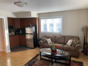 a living room with a couch and a table at Dragonfly Inn Loft & Walkout Suites in Sherwood Park