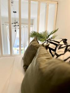 - un canapé blanc avec des oreillers et une plante dans l'établissement Belgrave Studio Apartments, Westminster London, à Londres