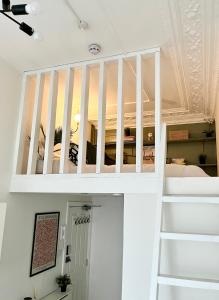 een trap naar een kamer met witte plafonds bij Belgrave Studio Apartments, Westminster London in Londen