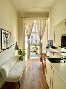 een keuken met een bank en een stoel voor een raam bij Belgrave Studio Apartments, Westminster London in Londen