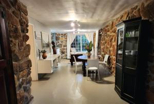 a dining room with a table and a stone wall at The Bardolino Artists Retreat in Nelspruit