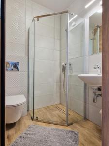 a bathroom with a shower and a toilet and a sink at Danusia in Dębki