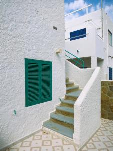 a white building with a green door and stairs at LLANO ALTO in San José