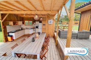 an outdoor kitchen and dining area on a wooden deck at Larimar Chambre d'hote in Léon