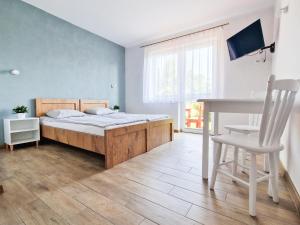 a bedroom with a bed and a table and a chair at Danusia in Dębki