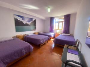 a hotel room with two beds and a tv at Amelita Hotel Boutique in Huaraz