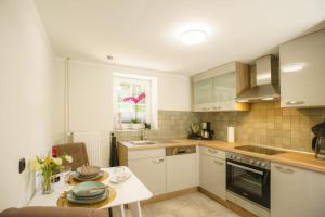 a kitchen with white cabinets and a table with plates on it at Ferienwohnung inmitten der Natur 