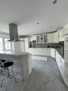 a large kitchen with white cabinets and a counter at Modernes Haus in Parndorf in Parndorf