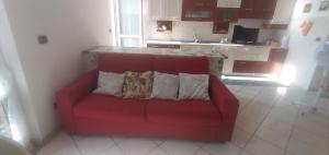 un divano rosso con due cuscini seduto in una cucina di Casa Ester ad Ascea