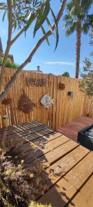 una valla de madera junto a una terraza de madera en Chambre d'hôtes Chante Cigale, en La Ciotat