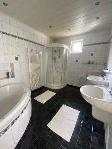 a bathroom with two sinks and a tub and two sinks at Modernes Haus in Parndorf in Parndorf