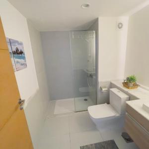 uma casa de banho branca com um chuveiro e um WC. em شالية بمراسي فرش فندقي السعر شامل الكروت em El Alamein