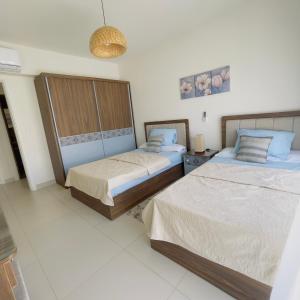 um quarto com duas camas num quarto em شالية بمراسي فرش فندقي السعر شامل الكروت em El Alamein