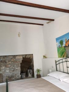 1 dormitorio con chimenea de piedra y 1 cama en Karlin's house Anzi - albergo diffuso, en Anzi