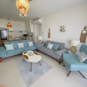 uma sala de estar com sofás azuis e uma mesa em شالية بمراسي فرش فندقي السعر شامل الكروت em El Alamein
