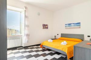 a bedroom with a yellow bed and a window at casa vacanza Laura in Genova