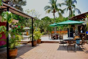 an outdoor patio with tables and chairs and umbrellas at Nopalero Hostel in Puerto Escondido