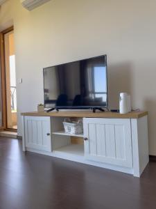 a white entertainment center with a large tv on a wall at Cabacum Beach Residence AP.19 in Varna City
