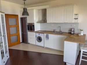 a kitchen with white cabinets and a washer and dryer at Cabacum Beach Residence AP.19 in Varna City