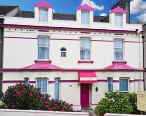 ein weißes Gebäude mit einem rosa Dach in der Unterkunft Station House Plymouth in Plymouth