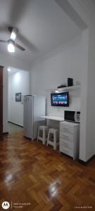 ein leeres Wohnzimmer mit einem Kühlschrank und einem Tisch in der Unterkunft Temporada Copacabana Salu 1 in Rio de Janeiro