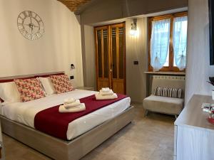 um quarto com uma cama e um relógio na parede em HappyHome Bilocale centro storico Rivarolo Canavese em Rivarolo Canavese