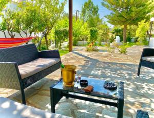 a patio with a couch and a coffee table at Villa Naya by the Beach in Anavyssos