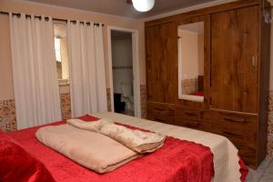 a bedroom with a large bed with a red blanket at Cantinho Bebler in Santa Teresa