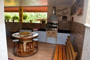 a kitchen with a table and chairs in a kitchen at Cantinho Bebler in Santa Teresa +23 photos
