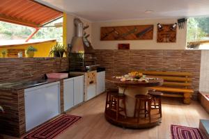 a kitchen with a table and some chairs in it at Cantinho Bebler in Santa Teresa