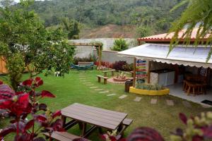 a backyard with a picnic table and a hammock at Cantinho Bebler in Santa Teresa
