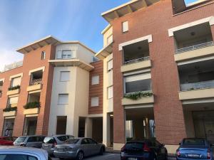 a building with cars parked in a parking lot at Le Miromí in Civitanova Marche