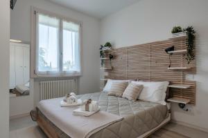 Un dormitorio con una cama grande con toallas. en Opera Apartment Sirmione, en Sirmione