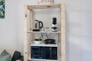 una cocina con una estantería con microondas. en Opera Apartment Sirmione, en Sirmione