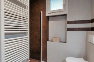 Un baño con inodoro y ventana. en Opera Apartment Sirmione, en Sirmione 26 fotos más