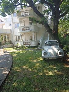 een oude auto geparkeerd in het gras voor een gebouw bij Apartments Mond in Sutomore
