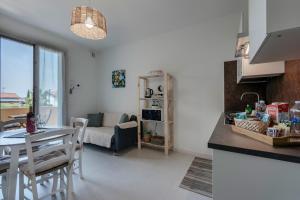 Una cocina y una sala de estar con mesa y sillas. en Opera Apartment Sirmione, en Sirmione