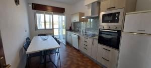 a kitchen with a white table and a white refrigerator at Piso Ribeira Sacra in Monforte de Lemos