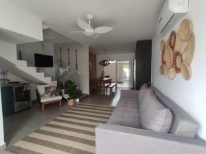un salon avec un canapé et un ventilateur de plafond dans l'établissement Casa de Condomínio em Maresias - Pertinho da praia, à Maresias