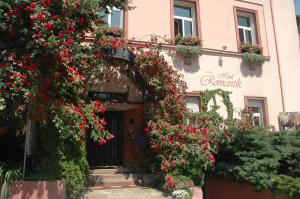 einen Eingang zu einem Gebäude mit roten Blumen in der Unterkunft Hotel Romantik Eger in Eger