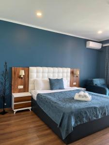 sypialnia z dużym łóżkiem z niebieską ścianą w obiekcie The Fresh Wave hotel w mieście Batumi