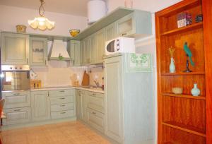  La cuisine est équipée de placards blancs et d'un réfrigérateur. dans l'établissement A Casa di Ale, à Sorso