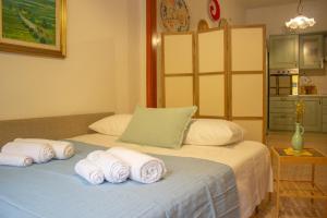 a bedroom with a bed with rolled towels on it at A Casa di Ale in Sorso