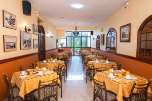 a restaurant with tables and chairs in a room at Hotel Manhattan Inn Airport in Lima