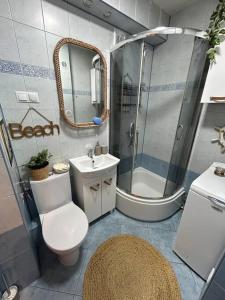 een badkamer met een douche, een toilet en een wastafel bij Apartament Sea Nest Brzeźno, blisko morza in Gdańsk