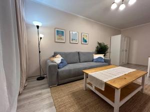 uma sala de estar com um sofá e uma mesa em Apartament Sea Nest Brzeźno, blisko morza em Gdansk