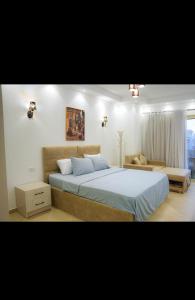 Binishty hurghada apartment في الغردقة: غرفة نوم بسرير كبير وأريكة