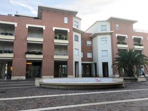 deux grands bâtiments avec une fontaine devant eux dans l'établissement Le Miromí, à Civitanova Marche