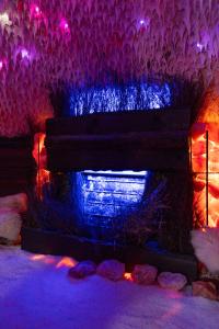 Pokój z kominkiem z fioletowymi i niebieskimi światłami w obiekcie Panorama Górska Wisła Resort & SPA w Wiśle